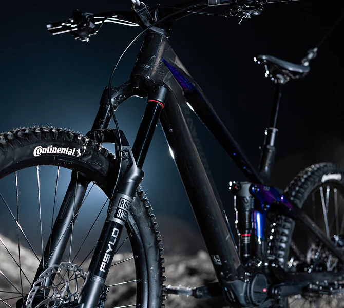 Raymon Tarok E-Mountainbike mit schwarzem Carbonrahmen, RockShox Psylo Federgabel und Continental Reifen.