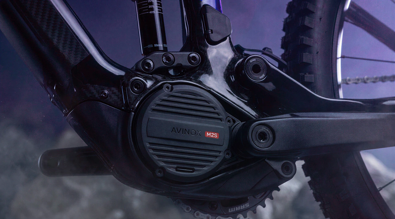 Nahaufnahme des Avinox M2S Motors am Carbonrahmen eines Raymon Tarok E-Mountainbikes vor felsigem Hintergrund.
