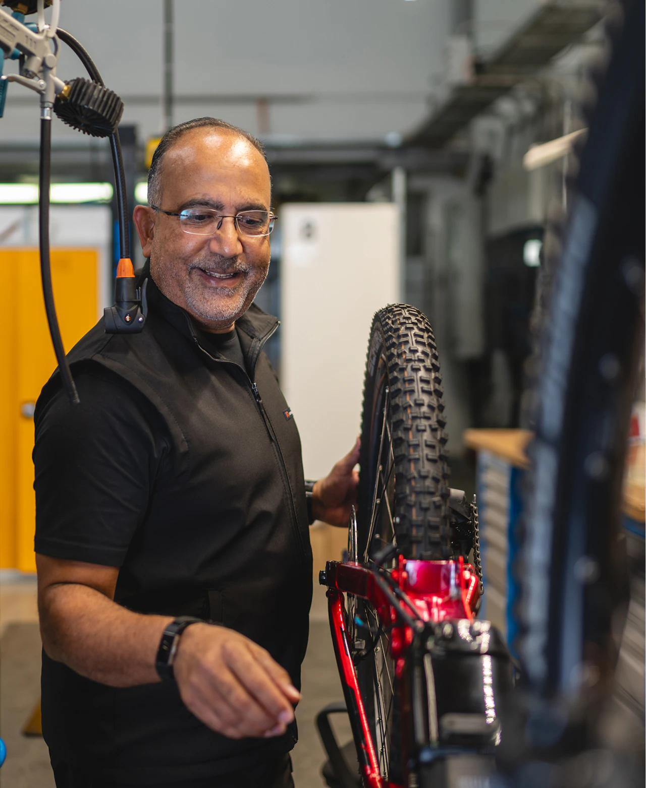 Felix Puello lächelt bei der Montage eines Raymon E-Bikes in der Werkstatt.