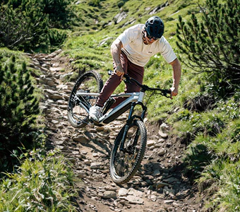 Mountainbiker fährt mit einem Raymon Durok E-Bike einen steilen Bergpfad hinauf.