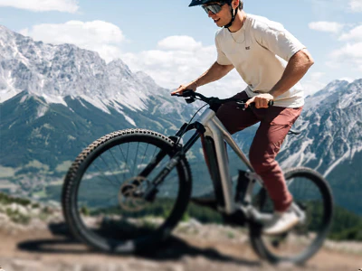 Mountainbiker fährt mit einem Raymon Durok E-Bike einen steilen Bergpfad hinauf.
